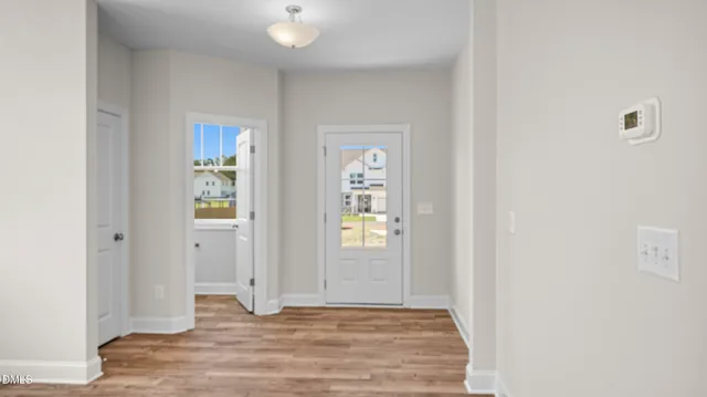 a view of an empty room with window and wooden floor