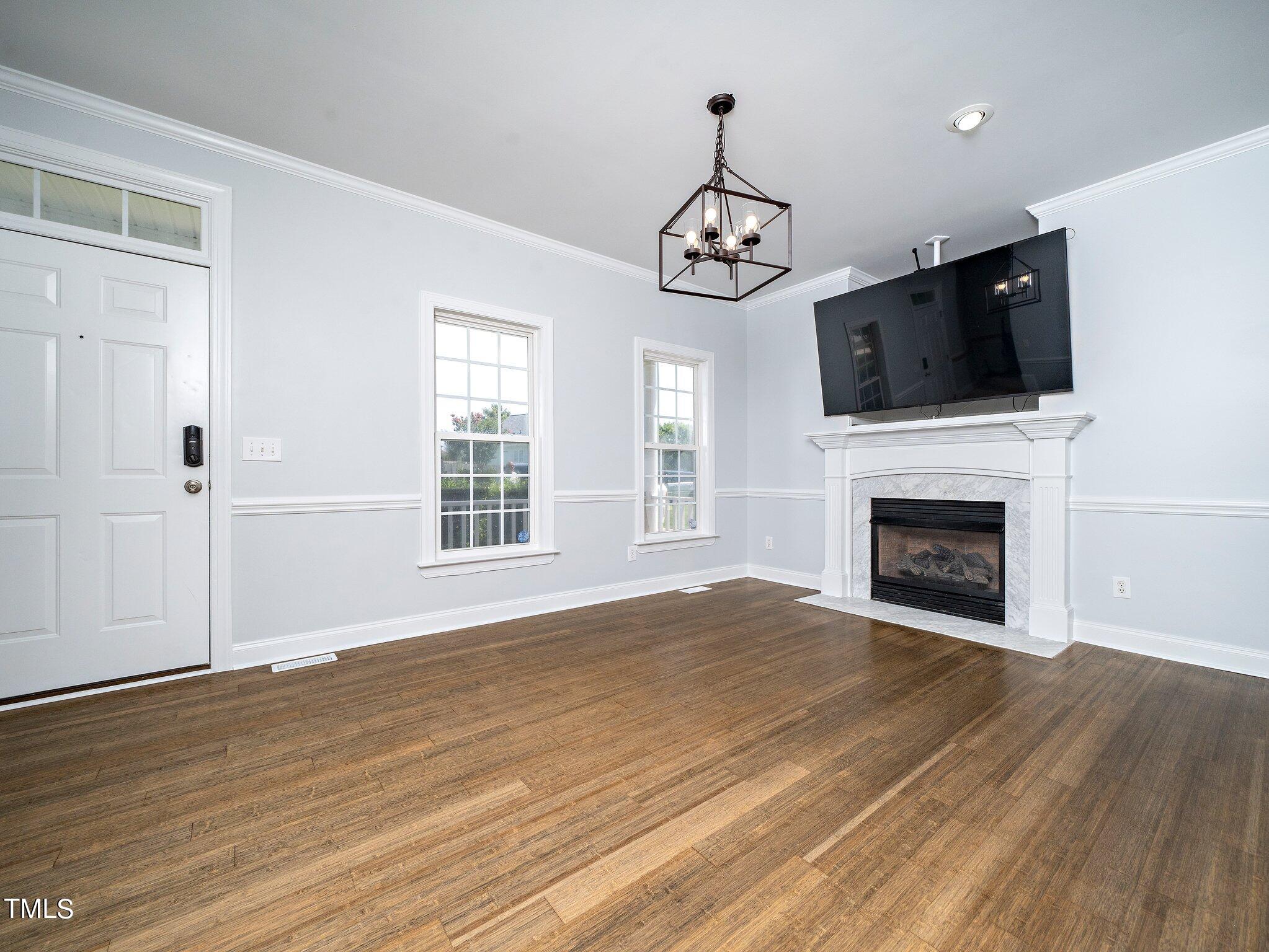 5004 Contender Drive Raleigh, NC 27603 - Photo 15 of 28 a view of an empty room with wooden floor fireplace and a window