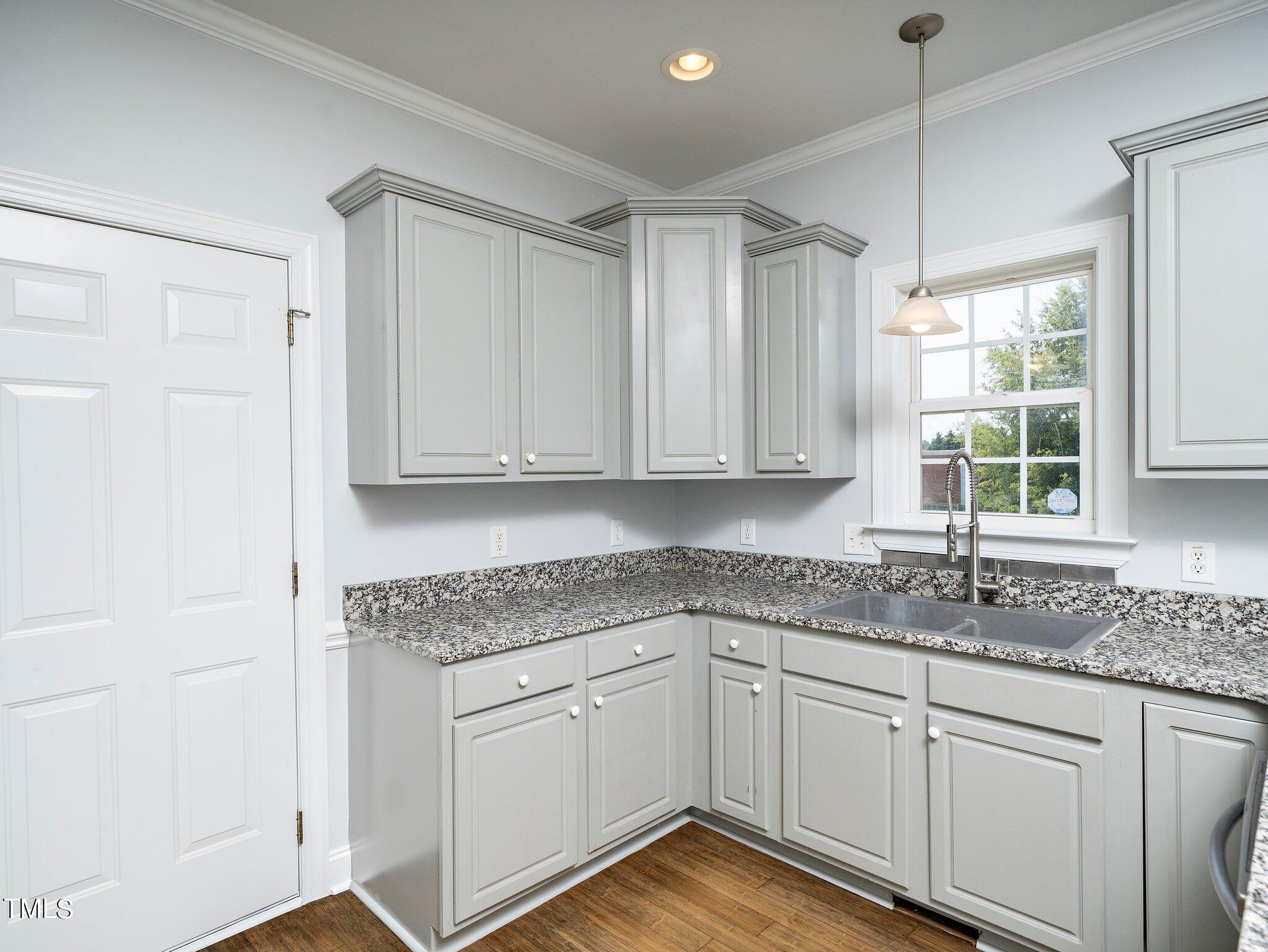 5004 Contender Drive Raleigh, NC 27603 - Photo 20 of 28 a kitchen with granite countertop white cabinets and white appliances