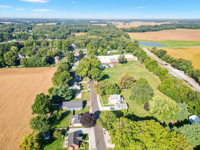 an aerial view of ocean and residential houses with outdoor space