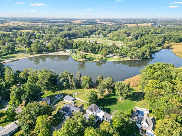 an aerial view of a residential houses with outdoor space and lake view