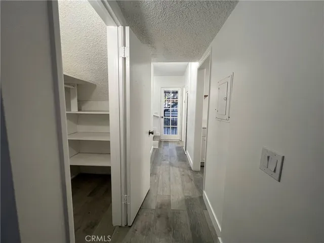 a view of a hallway with wooden floor and closet