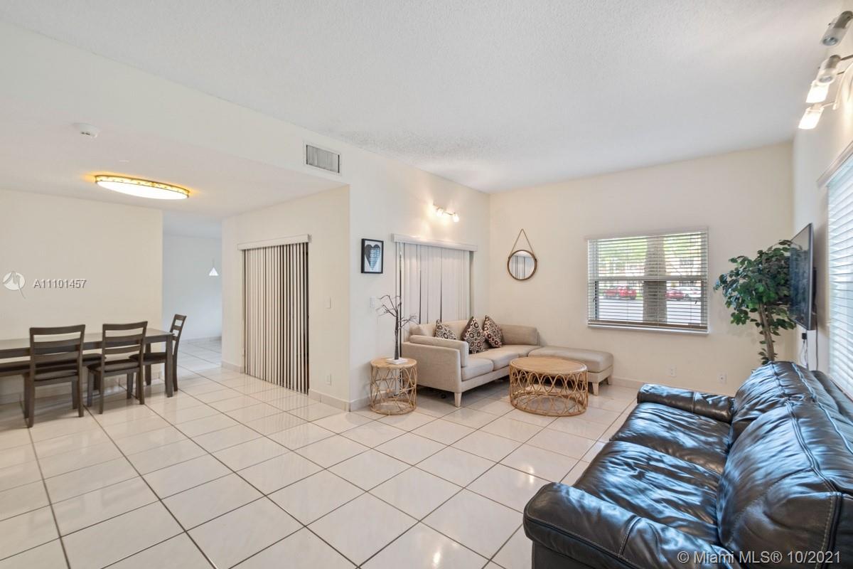 501 Racquet Club Road, Unit 61 Weston, FL 33326 - Photo 2 of 17 a living room with furniture and a dining table with kitchen view