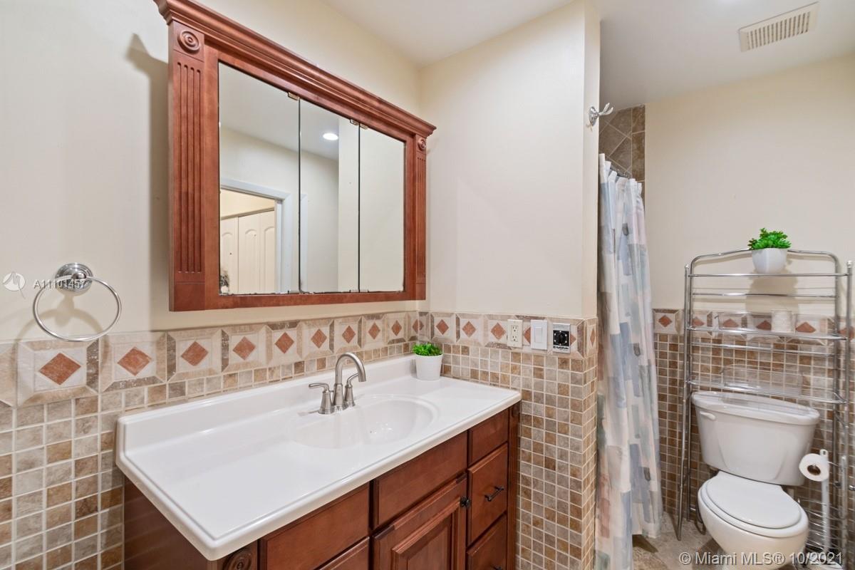 501 Racquet Club Road, Unit 61 Weston, FL 33326 - Photo 17 of 17 a bathroom with a sink toilet and mirror
