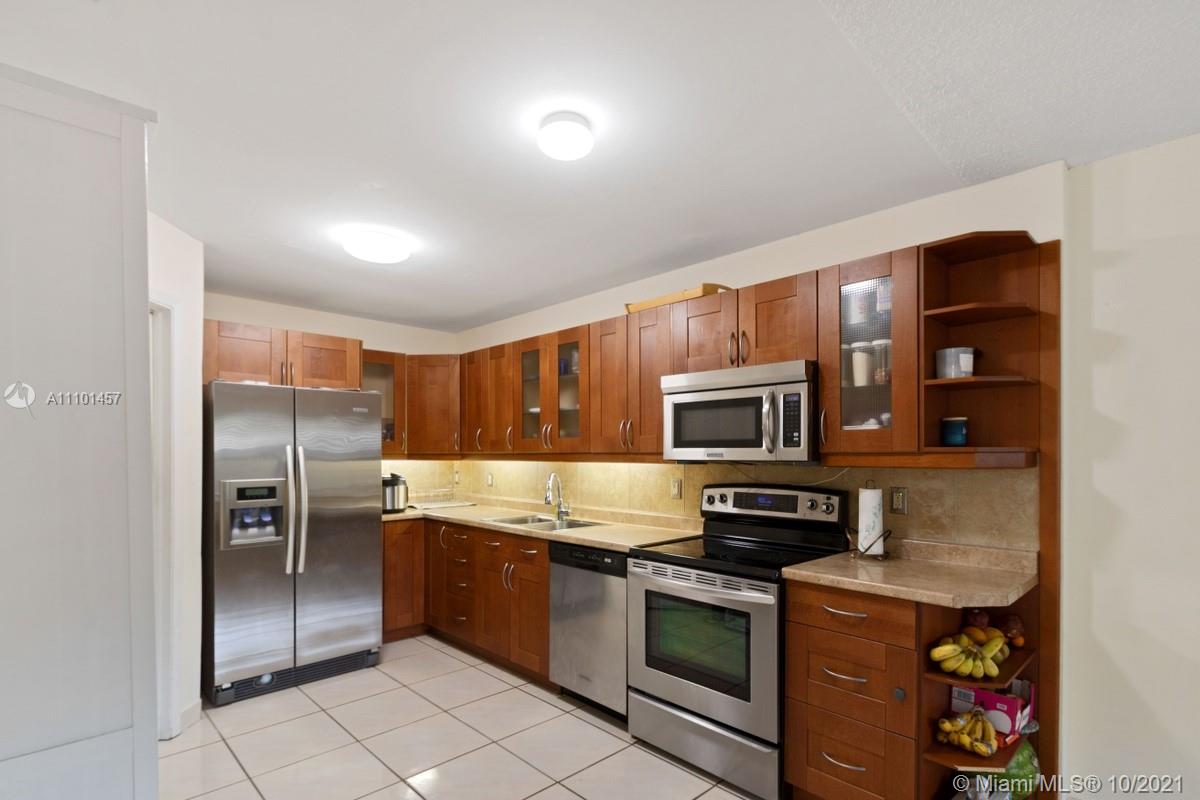 501 Racquet Club Road, Unit 61 Weston, FL 33326 - Photo 6 of 17 a kitchen with granite countertop a refrigerator and a stove top oven