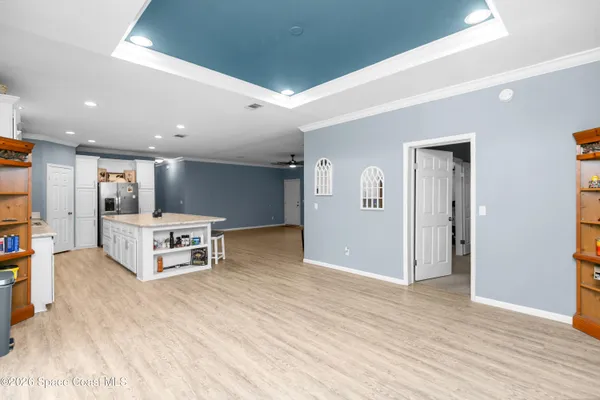 a living room with stainless steel appliances kitchen island furniture and wooden floor
