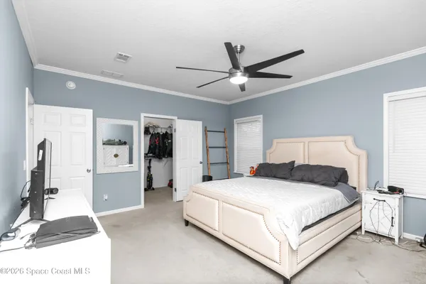 a bedroom with a large bed and a chandelier