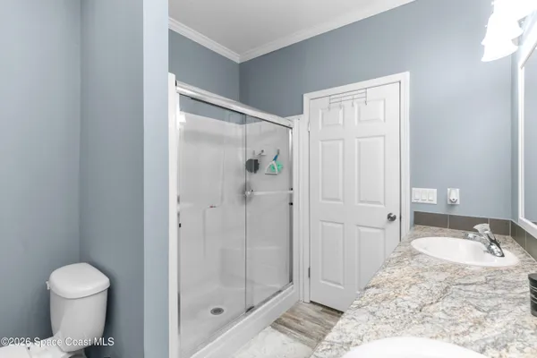 a bathroom with a granite countertop sink a toilet and shower