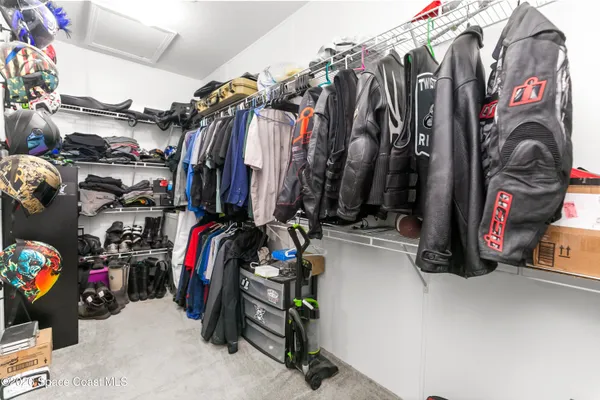 a view of walk in closet with clothes