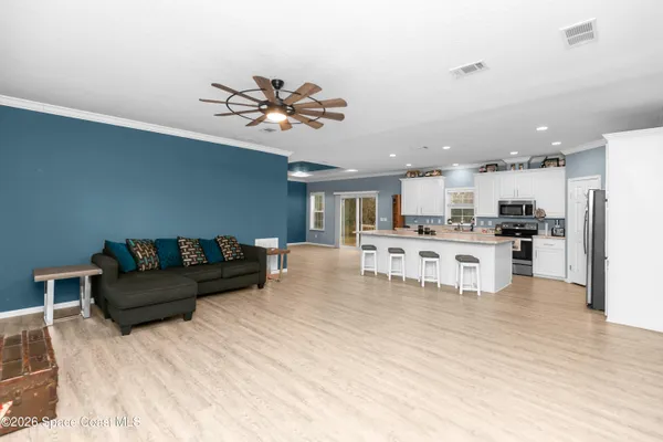 a living room with furniture and kitchen view