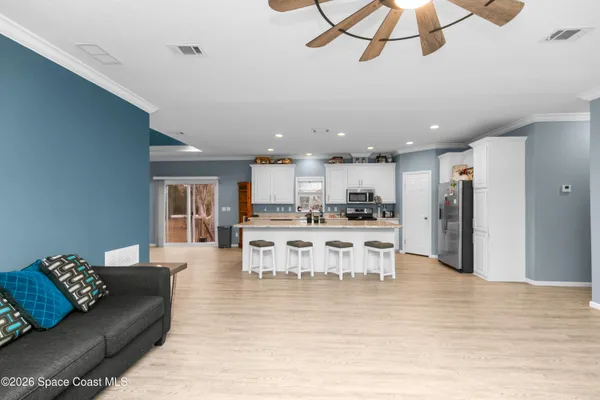 a living room with stainless steel appliances kitchen island granite countertop furniture and a kitchen view