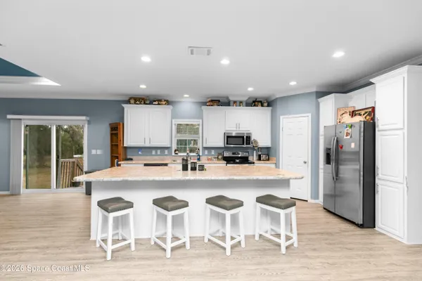 a kitchen with stainless steel appliances kitchen island granite countertop a refrigerator and a stove top oven