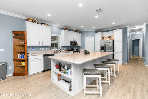 a kitchen with stainless steel appliances kitchen island granite countertop a stove a sink and a refrigerator