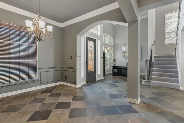 a view of a hallway with entryway door and chandelier