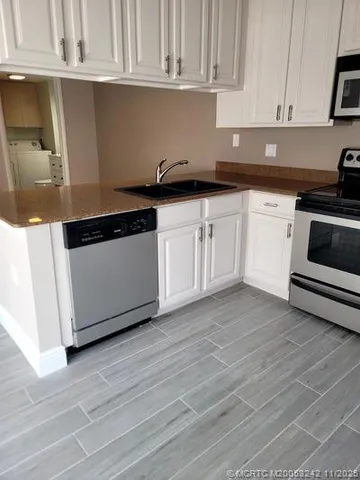 a kitchen with granite countertop white cabinets and white appliances