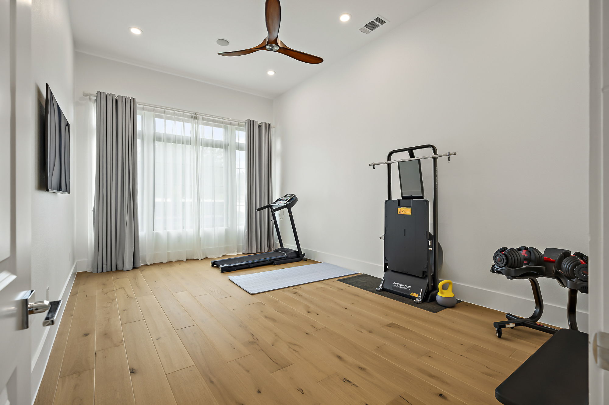 10211 Thistle Ridge Austin, TX 78733 - Photo 23 of 39 Workout room with ceiling fan, wood-type flooring, baseboards, and recessed lighting
