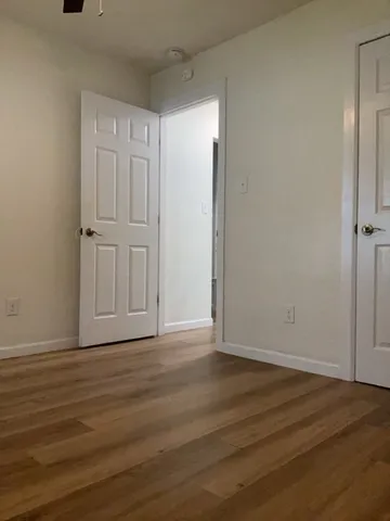 a view of an empty room with wooden floor