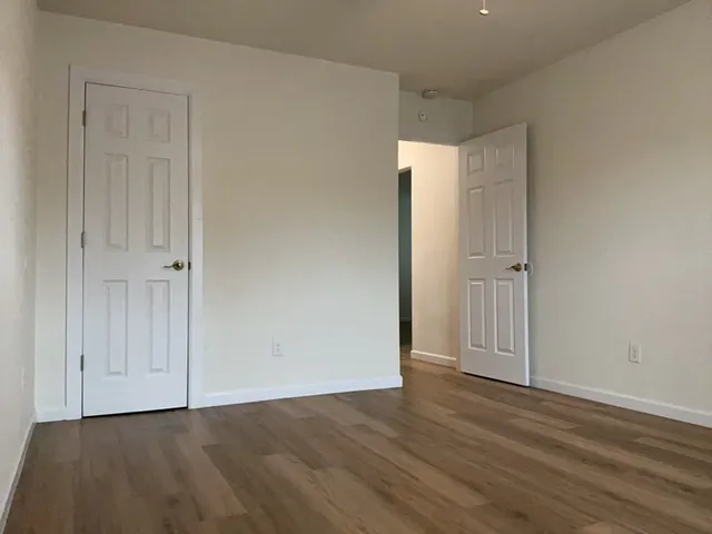 a view of an empty room with wooden floor