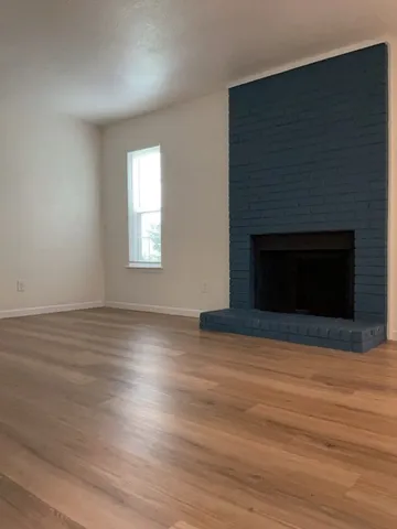 an empty room with wooden floor and fireplace