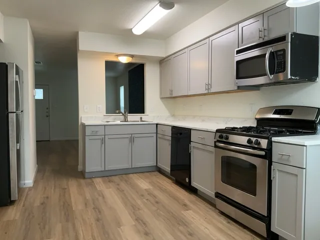 a kitchen with stainless steel appliances white cabinets and sink