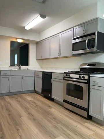 a kitchen with stainless steel appliances kitchen island a sink and a microwave