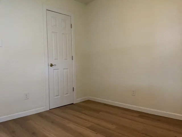 a view of an empty room with wooden floor