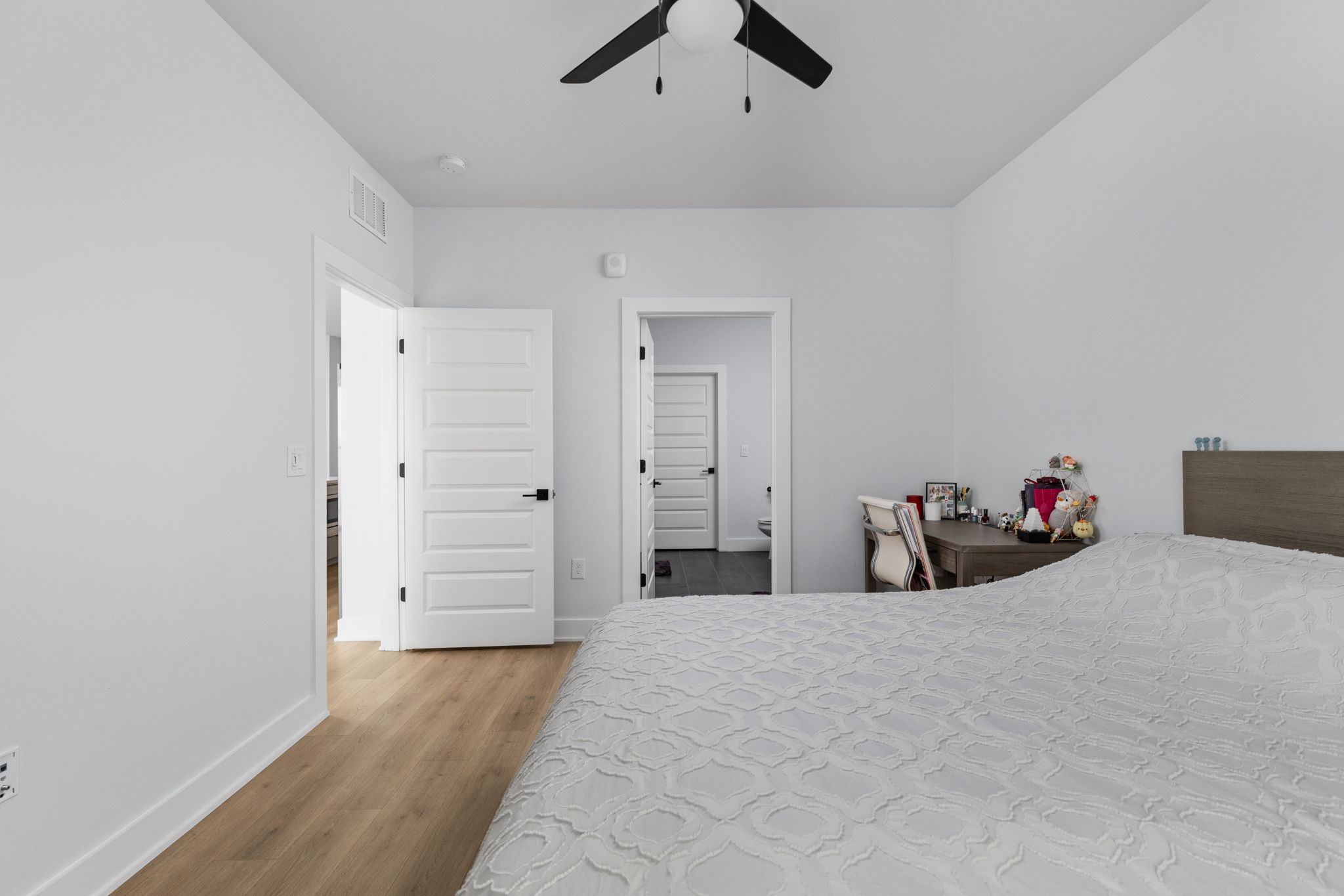 2500 Longview Street, Unit 405 Austin, TX 78705 - Photo 12 of 28 Bedroom with light wood-style flooring, a ceiling fan, and ensuite bath