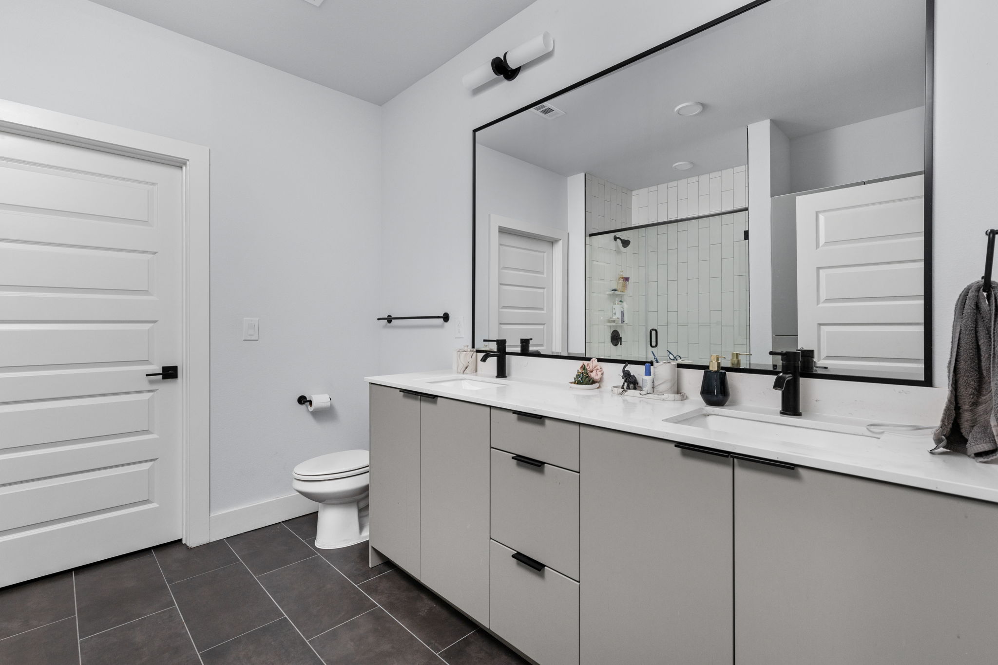 2500 Longview Street, Unit 405 Austin, TX 78705 - Photo 13 of 28 Full bath with double vanity, a shower stall, and dark tile patterned flooring