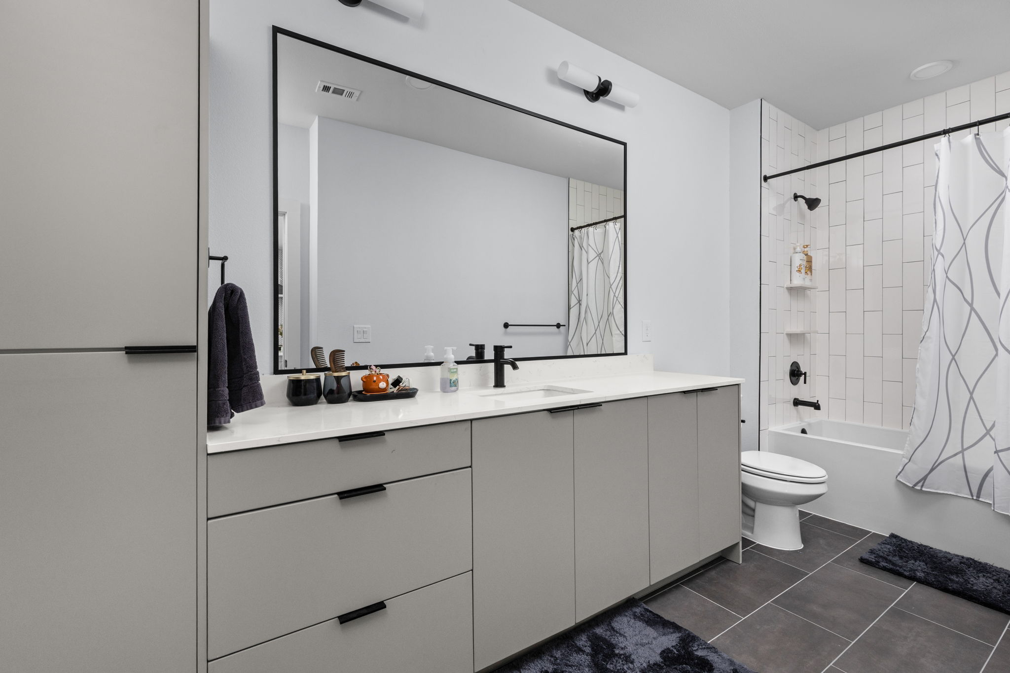 2500 Longview Street, Unit 405 Austin, TX 78705 - Photo 18 of 28 Bathroom featuring vanity, shower / tub combo with curtain, and dark tile patterned floors