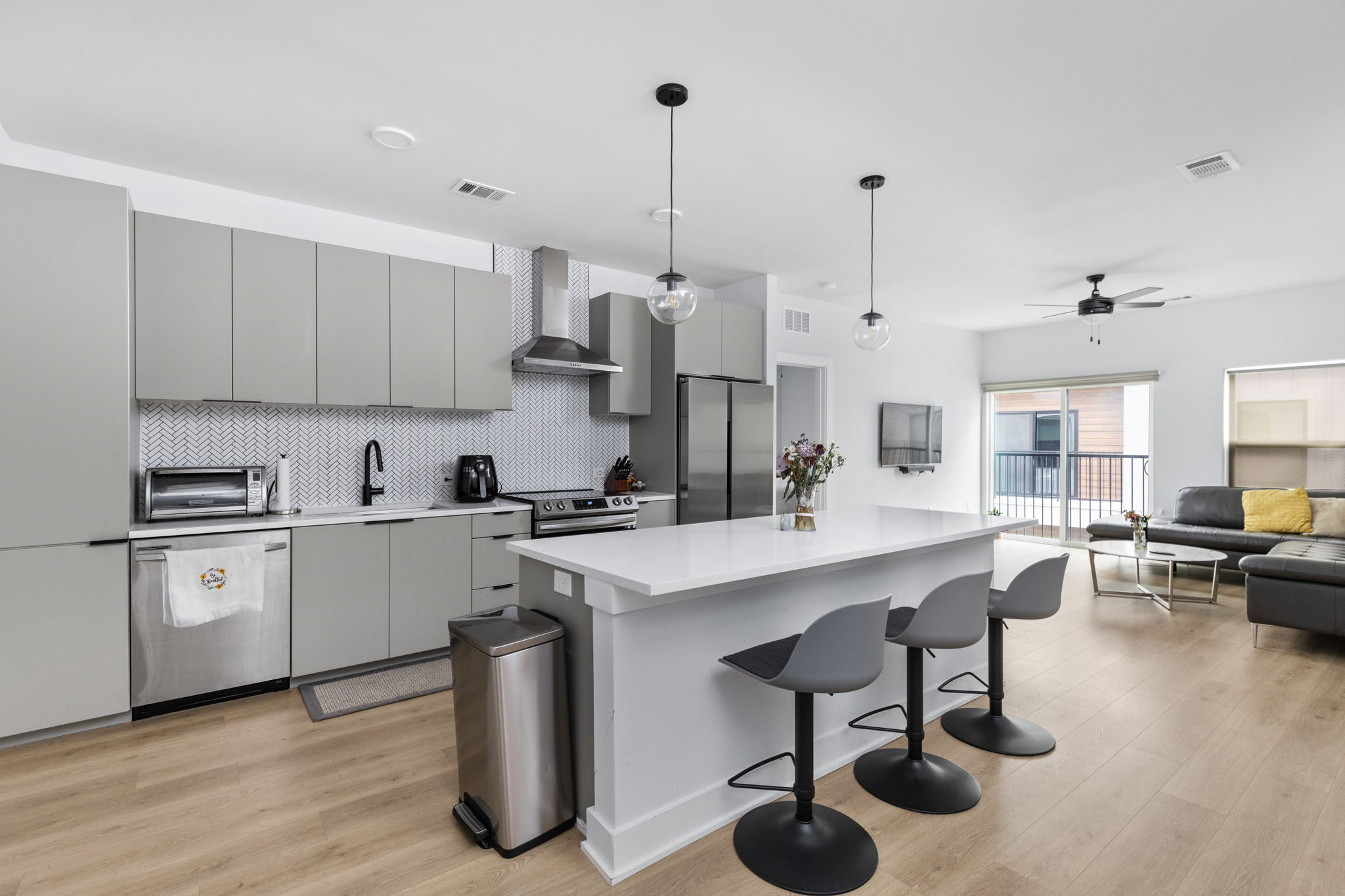 2500 Longview Street, Unit 405 Austin, TX 78705 - Photo 28 of 28 Kitchen with hanging light fixtures, light wood-style flooring, a center island, open floor plan, and stainless steel appliances