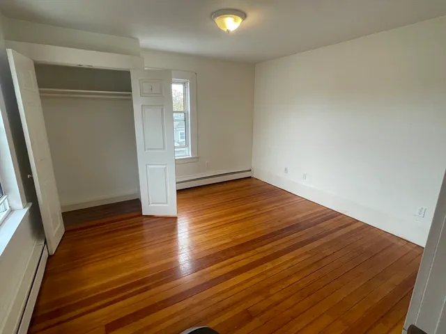 a view of room with window and wooden floor