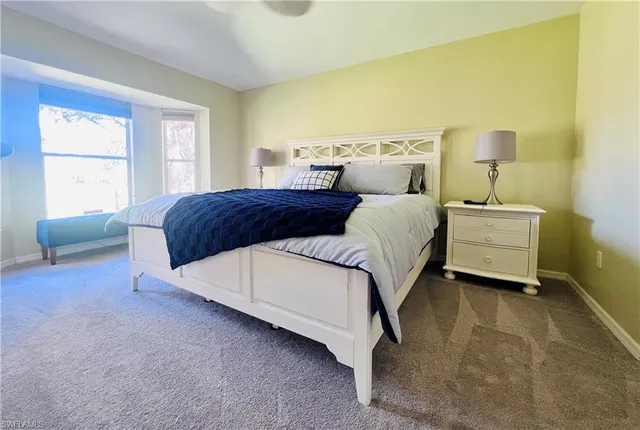 a bedroom with a bed lamp and a window