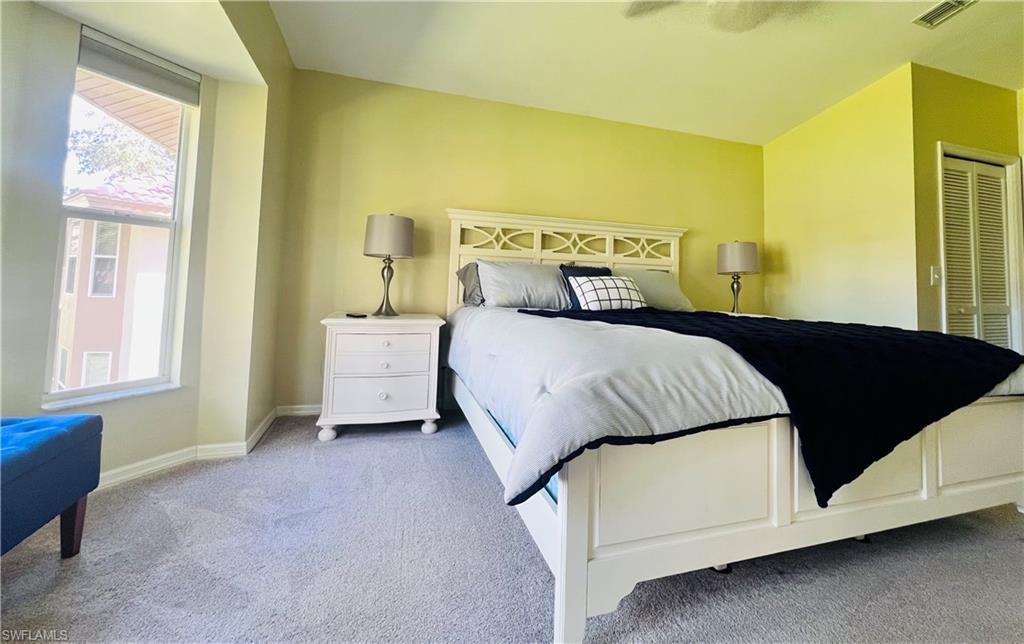 8073 Panther Trail, Unit 1404 Naples, FL 34113 - Photo 13 of 28 a bedroom with a bed and window