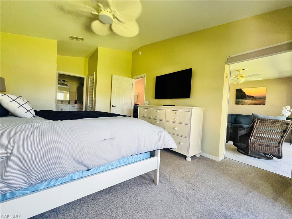 8073 Panther Trail, Unit 1404 Naples, FL 34113 - Photo 14 of 28 a bedroom with a bed and a flat screen tv