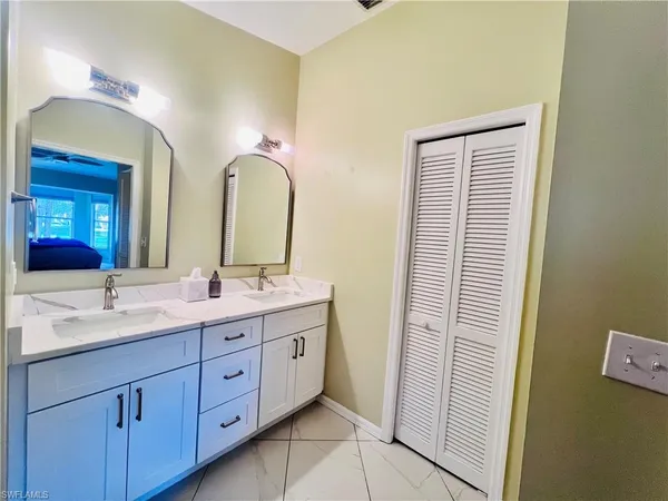 a spacious bathroom with a double vanity sink and a mirror