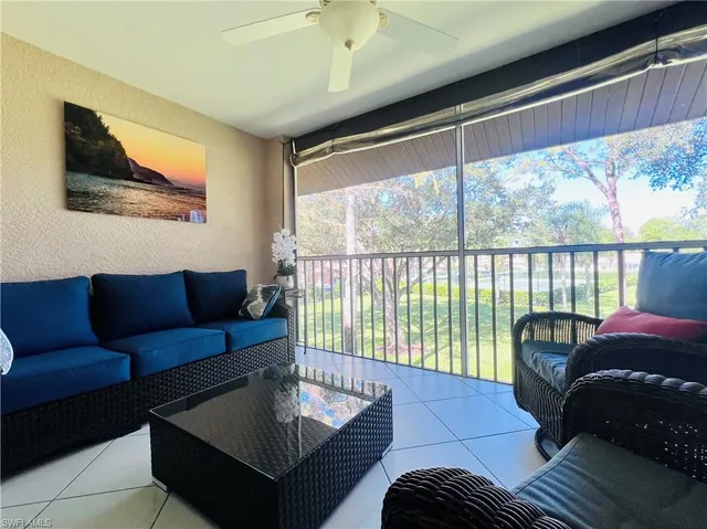 a living room with furniture and a floor to ceiling window