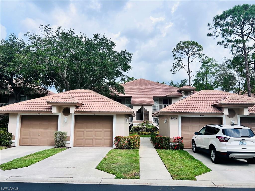 8073 Panther Trail, Unit 1404 Naples, FL 34113 - Photo 25 of 28 a front view of a house with garden