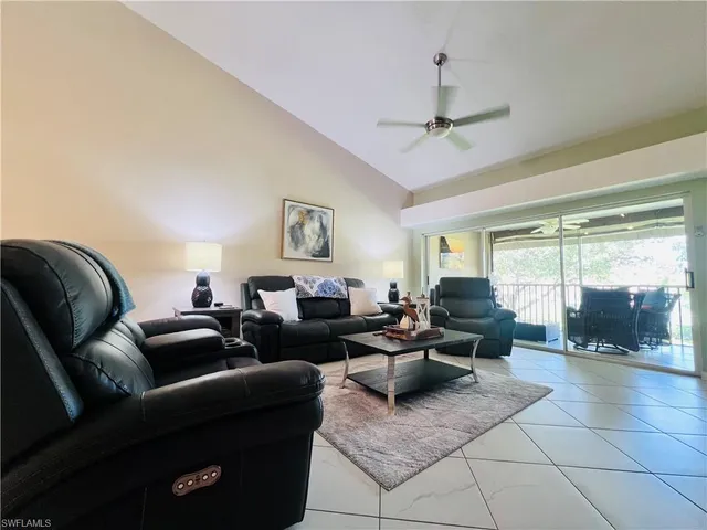 a living room with furniture and a floor to ceiling window