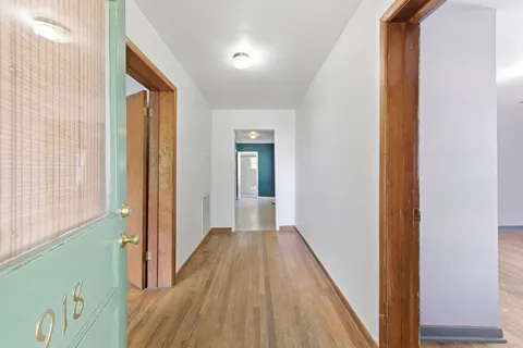 a view of a hallway with wooden floor and staircase