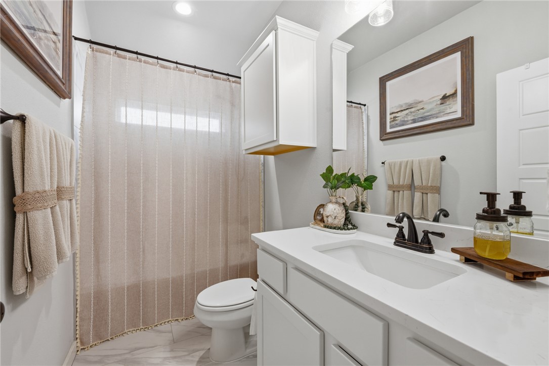 3112 Margaret Rudder Parkway Bryan, TX 77808 - Photo 18 of 24 a bathroom with a sink a toilet and shower