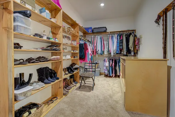 a view of walk in closet with clothes and shoes