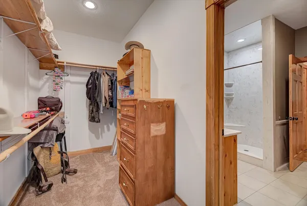 a view of a storage & utility room with closet fridge and window