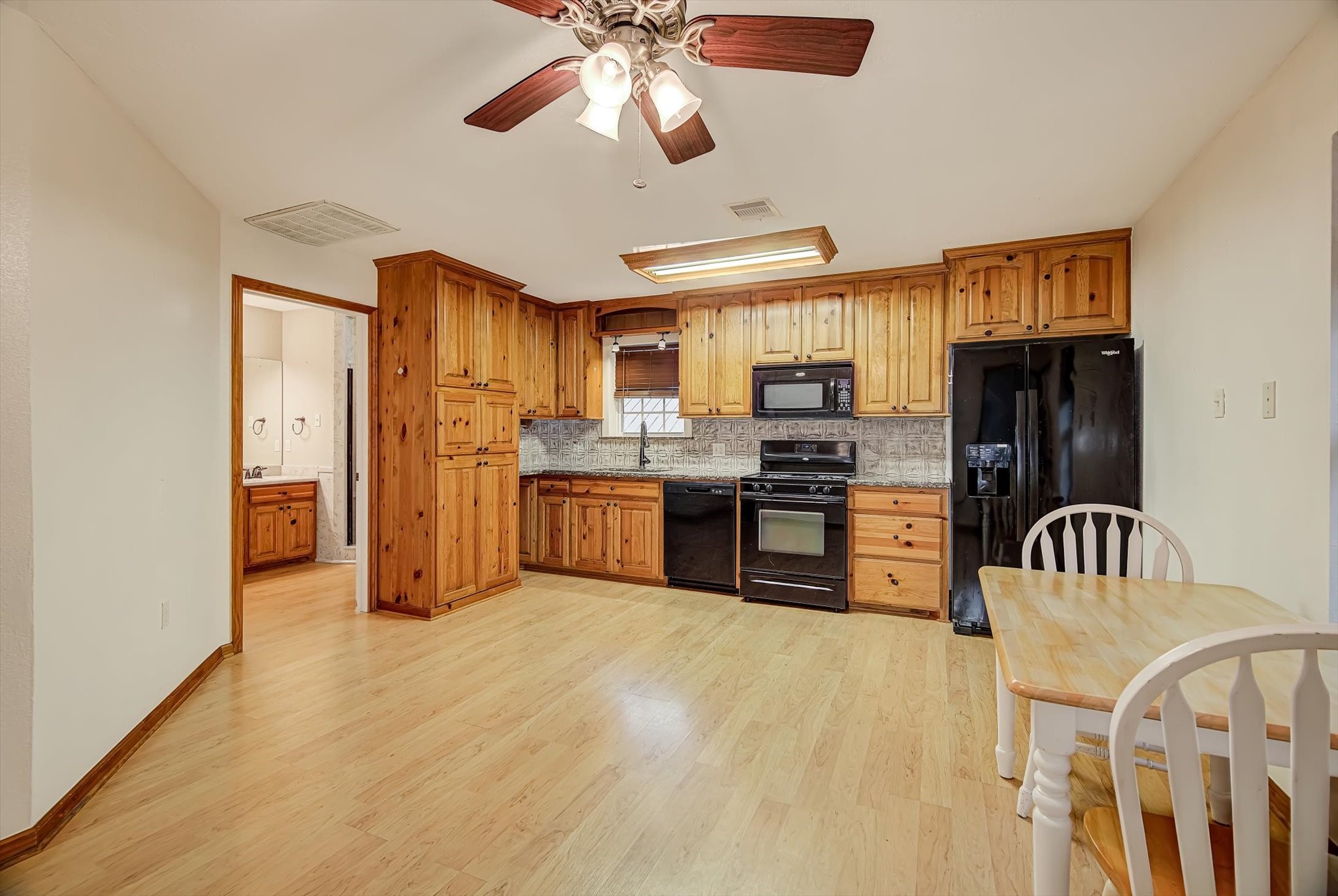 20205 Highway 146 Liberty, TX 77575 - Photo 39 of 50 a kitchen with stainless steel appliances granite countertop a stove top oven a refrigerator a sink a dining table and chairs with wooden floor