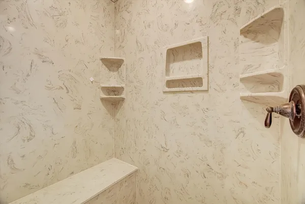 a view of an empty room with a chandelier fan