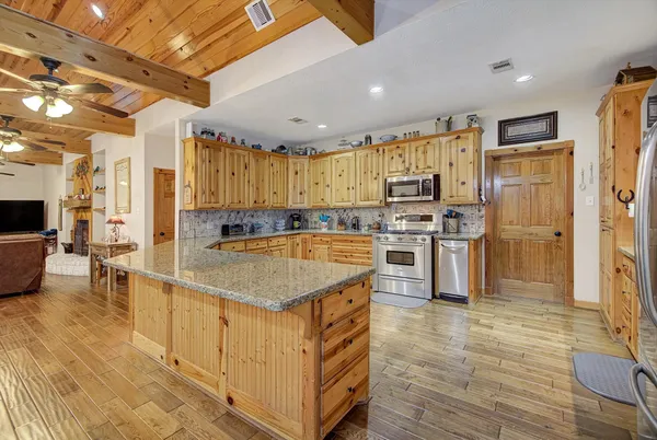a kitchen with stainless steel appliances granite countertop a sink a stove and a refrigerator