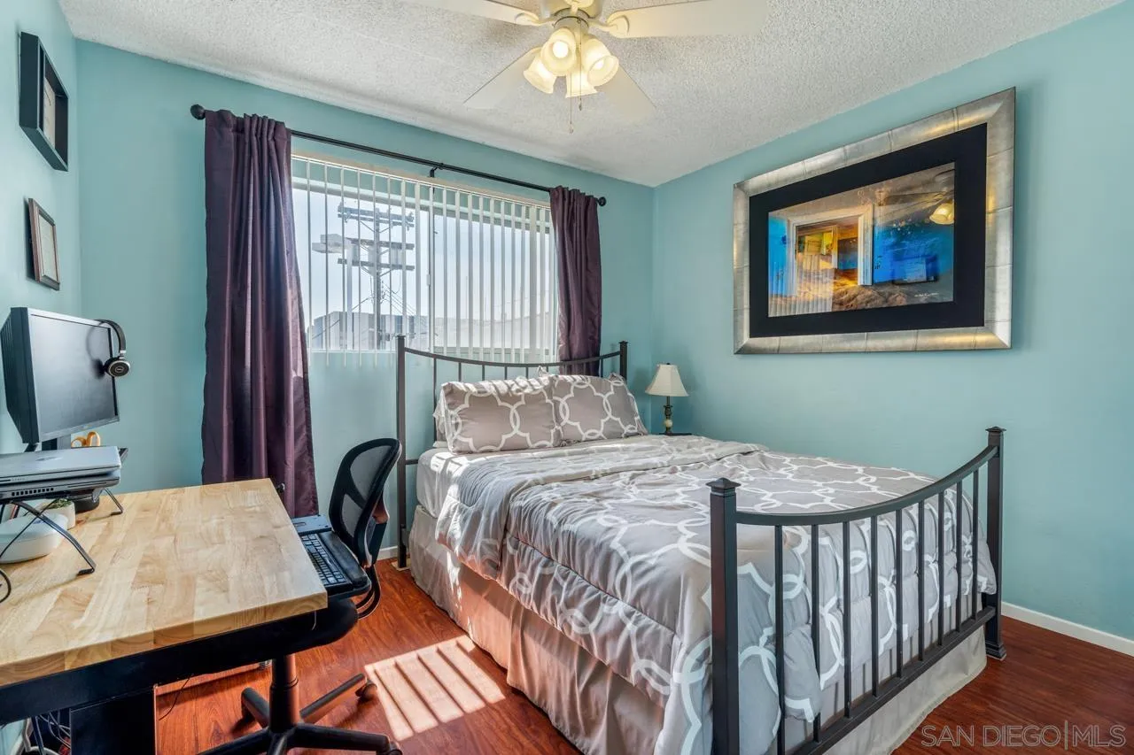 4530 Vandever Avenue, Unit 6 San Diego, CA 92120 - Photo 13 of 25 a bedroom with a bed and a chandelier