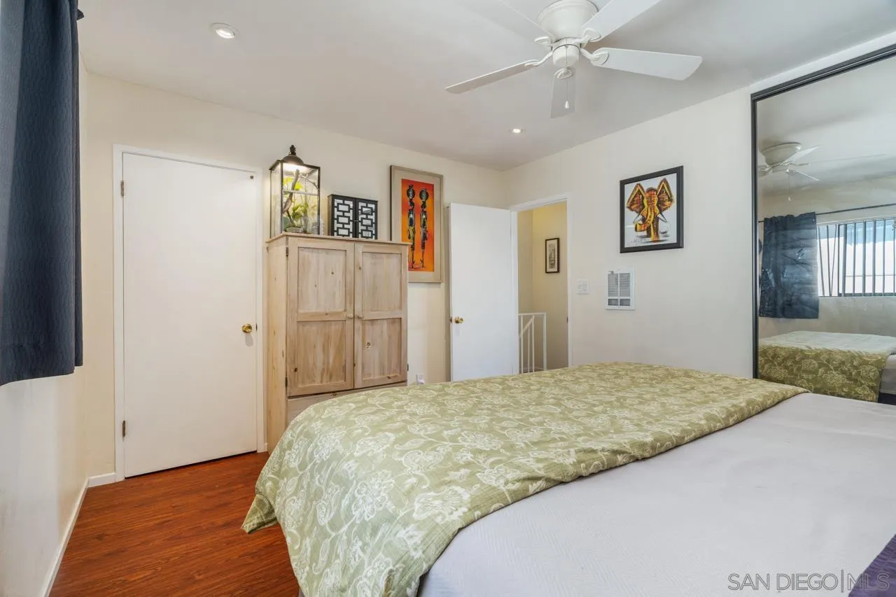4530 Vandever Avenue, Unit 6 San Diego, CA 92120 - Photo 19 of 25 a bedroom with a bed and a chandelier