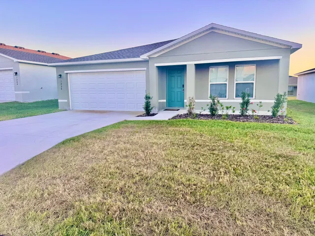 a backyard of a house with table and chairs