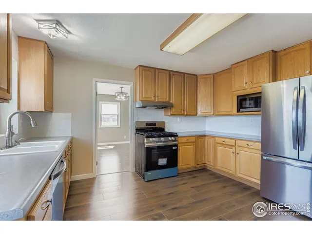 a kitchen with stainless steel appliances granite countertop a stove a sink and a refrigerator