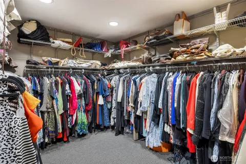 a view of walk in closet with clothes and shoes